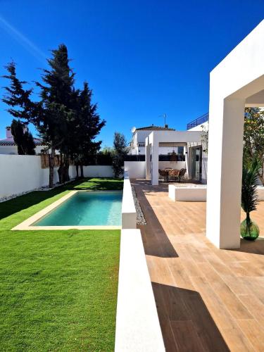 a villa with a swimming pool and a yard at Apartaments Gorgot in Empuriabrava