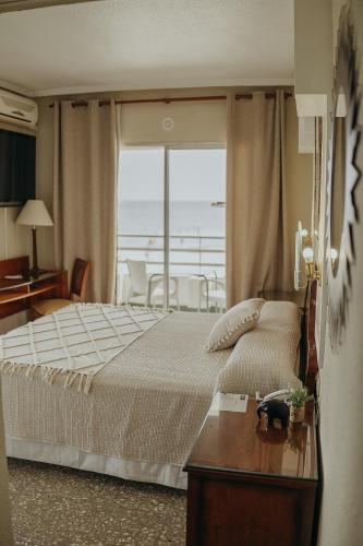 a bedroom with a bed with a view of the ocean at Hotel Polamar in Santa Pola