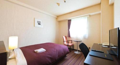 a hotel room with a bed and a desk at Daini Fuji Hotel in Nagoya