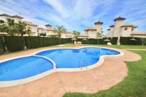 a swimming pool in the yard of a house at Preciosa casa adosada en Orihuela Costa in Playas de Orihuela