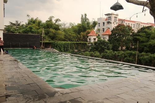 a swimming pool in front of a building at Terrace Hills Villa Malang in Karangploso