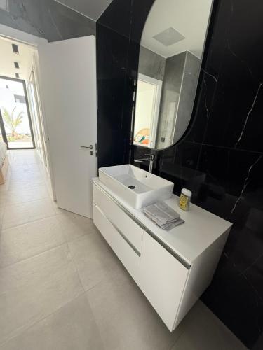 a bathroom with a white sink and a mirror at Stylish and comfortable Villa Anna in Villaverde in Lajares