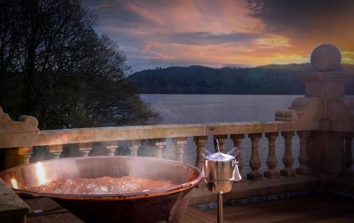 a bath tub on a balcony with a view of the water at Langdale Chase Hotel in Windermere
