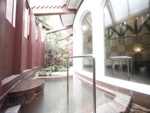 a hallway of a building with a table in the water at Unzen Kanko Hotel in Unzen