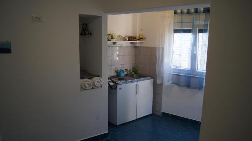 a small kitchen with a sink and a stove at Micro Rooms in Šibenik