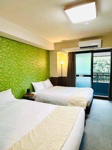 a hotel room with two beds and a window at Kyoto Sanjo Ohashi in Kyoto