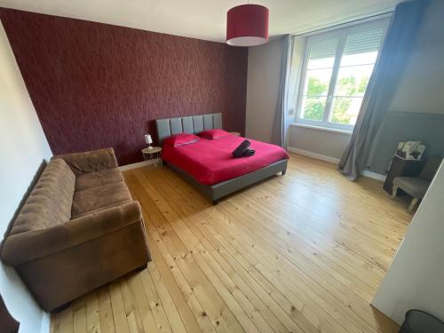 a bedroom with a red bed and a couch at Les Croisés&Spa in Azannes-et-Soumazannes