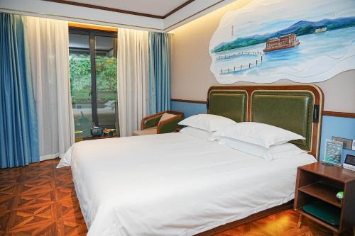 a bedroom with a large bed with a painting on the wall at Nost algia S Hotel Hangzhou West Lake & Lingyin Temple 时光漫步S酒店杭州西湖店 Free laundry service, Free fresh ground coffee in Hangzhou