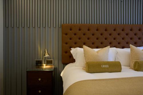 a bedroom with a bed with a headboard and a table at Harbour Hotel & Spa Guildford in Guildford