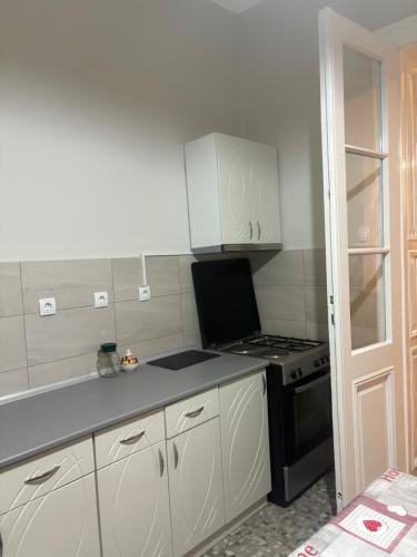 a small kitchen with a stove and white cabinets at Apartman 2 Pajić in Odžaci