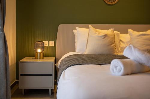 a bedroom with a bed and a lamp on a night stand at The Penthouse by Shmoo - Sliema Ferries in Sliema