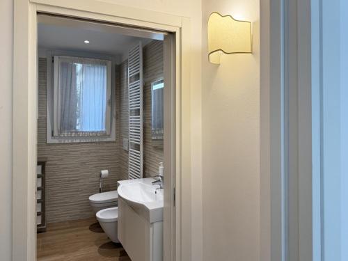 a bathroom with a white toilet and a sink at Dimora 5318 Venice in Venice