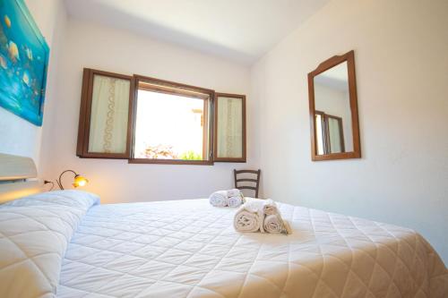 a bedroom with a large white bed with towels on it at Casa delle Sorgenti 2 in Torpè