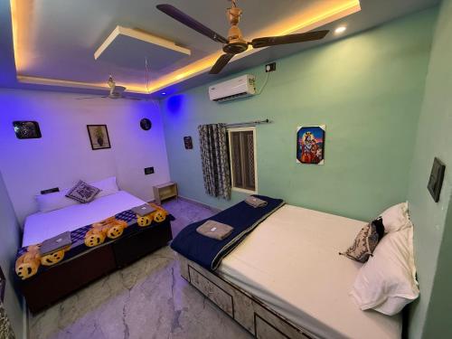 two beds in a room with purple lights at Roshini Homestay Hampi in Hampi