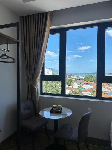 a room with a table and two chairs and a window at Hilaria Hotel in Vạn Ninh