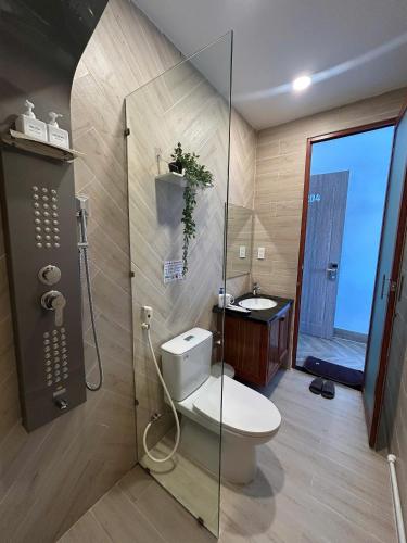 a bathroom with a toilet and a shower and a sink at Hilaria Hotel in Vạn Ninh