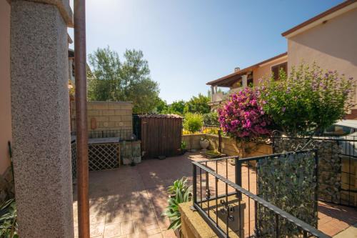 a patio with a fence and flowers in a yard at Casa delle Sorgenti 2 in Torpè