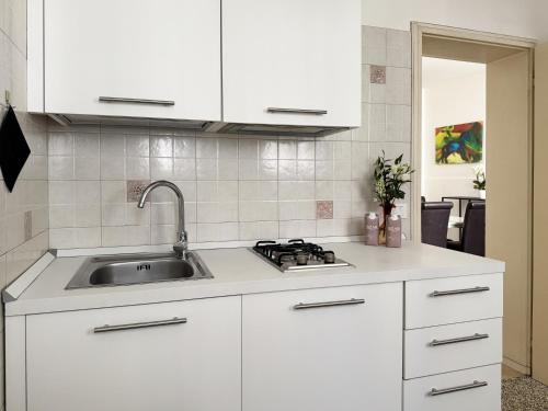 a kitchen with white cabinets and a sink at Dimora 5318 Venice in Venice