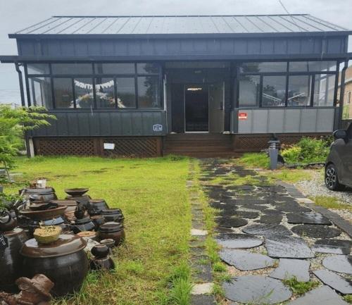 a house with a bunch of pots and pans in front of it at Buyeo Eoksae Jeongwon Pension in Buyeo