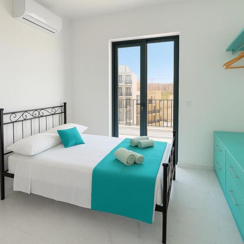 a bedroom with a large bed with two pillows on it at GuestHost - Penthouse with Jacuzzi in Gozo Island! in Marsalforn