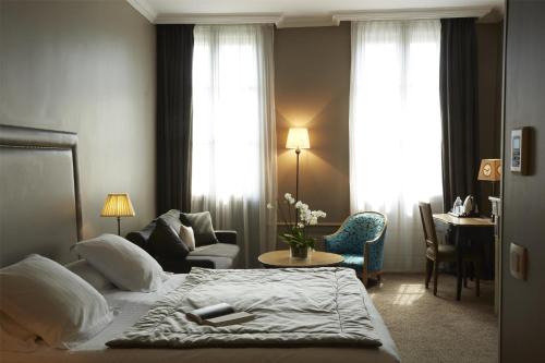 a hotel room with a bed and a living room at Best Western Plus d'Europe et d'Angleterre in Mâcon