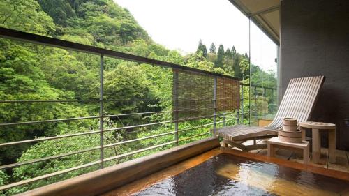 a balcony with a bench and a view of a mountain at Myoken Ishiharaso in Kirishima