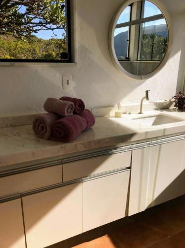 a bathroom with a sink and towels on a counter at Casa Miralago in Santana do Riacho