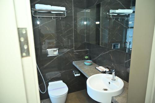 a bathroom with a sink and a toilet and a shower at Urvi Banquets & Guest House in kolkata