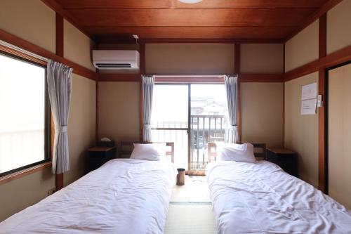 富山市にあるGuesthouse KENの窓のある部屋にベッドが2つある