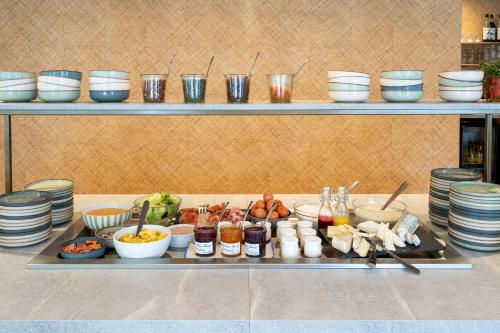 a buffet with plates and bowls and food on a table at Sure Hotel by Best Western Tours Sud in Chambray-lès-Tours