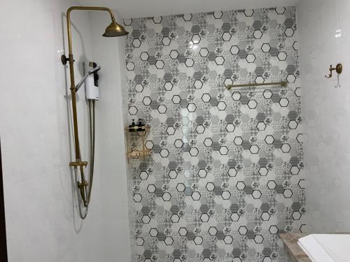 a shower with a gray and white shower curtain at Lemon Guesthouse in Chiang Mai