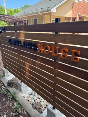 a wooden bench with a house sign on it at 那須青木 Fabulous House 一棟貸 BBQ in Nasushiobara