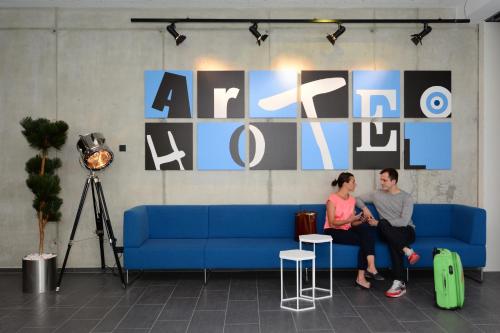 a man and a woman sitting on a blue couch at arte Hotel Kufstein in Kufstein