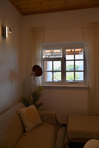 a living room with a couch and a window at Rastoni Apartments Skiathos in Troulos