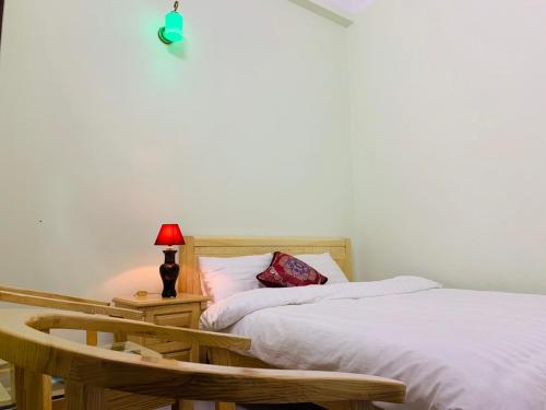 a bedroom with two beds and a table and a lamp at Tùng Long Hotel in Thanh Hóa