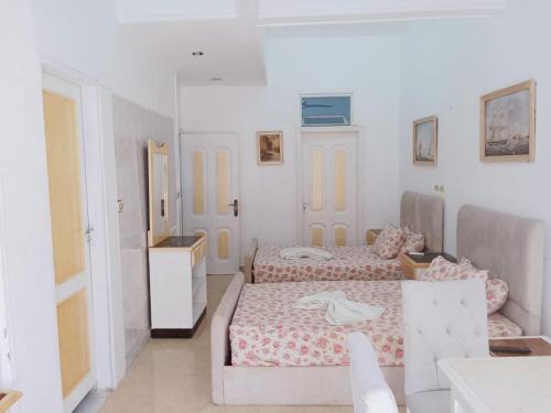 エル・アラメインにある3B basement Chalet 4beds 2 bed rooms with pool view114 green beachのベッド2台とソファのある寝室