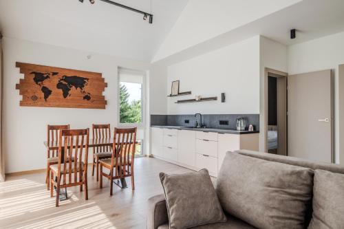 ein Wohnzimmer mit Sofa, Tisch und Stühlen in der Unterkunft TOPOLIŲ Apartamentai in Palanga