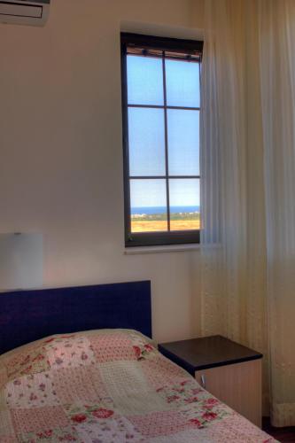 a bedroom with a bed and a window at Vis Velika in Velika
