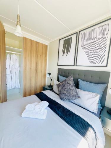 a bedroom with a white bed with towels on it at The Lagoon in Pretoria