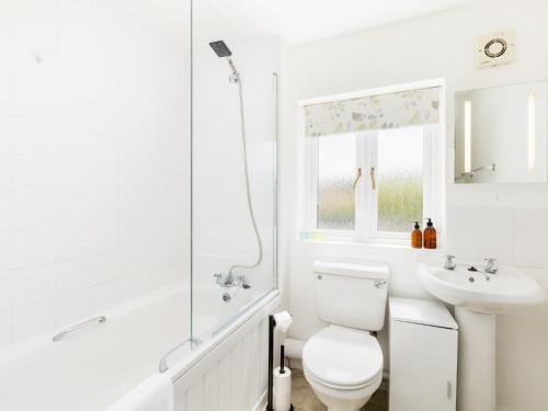 a white bathroom with a toilet and a sink at Delightful home Sunroom Garden Parking Pass the Keys in Moreton in Marsh