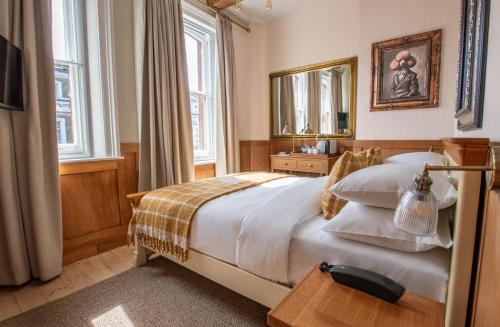 a bedroom with a large bed and a mirror at The Old Farmhouse Pub and Rooms in London