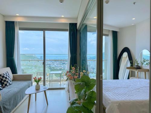a bedroom with a bed and a couch and a balcony at The Song Boutique Apartment in Vung Tau