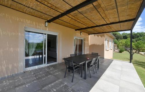 Saint-Michel-d'EuzetAwesome Home In Saint-Michel-D'euzet的屋顶下有桌椅的露台