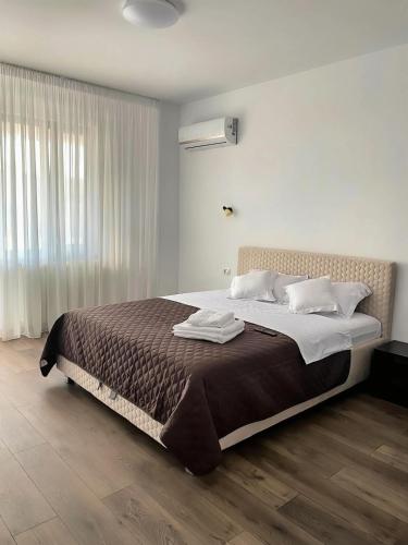 a bedroom with a large bed and a window at Maryon in Constanţa