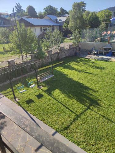 a yard with a bench in the grass at Tuz House R7 in Bakuriani
