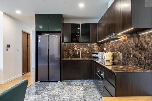 a kitchen with brown cabinets and a stainless steel refrigerator at Lumiere Horizon Suites in Ho Chi Minh City