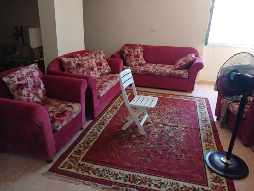 a living room with two couches and a chair on a rug at Flores casas de playa in Alexandria
