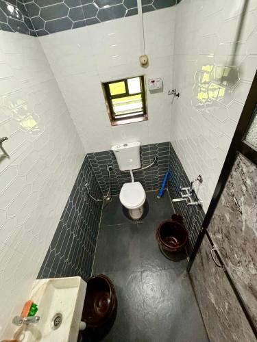 a bathroom with a toilet and a sink and a window at Siddhi Farm Kolad in Kolād