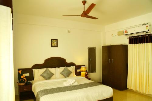 um quarto com uma cama e uma ventoinha de tecto em Ebenezer Plaza em Nedumbassery