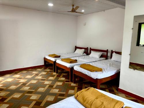 a room with four beds in it with a ceiling at Siddhi Farm Kolad in Kolād